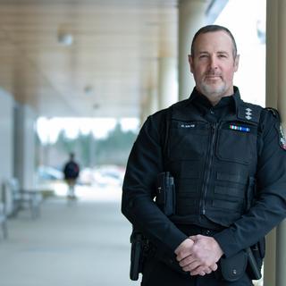 Drew Milne portrait next to VIU's Centre for Health and Science