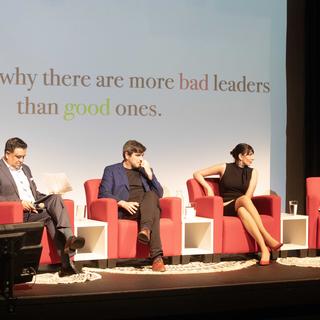 Four people sit on a stage together