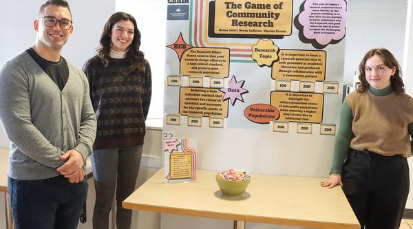 three people stand in front of a poster