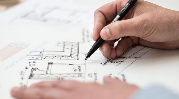 hands sketching an architectural drawing
