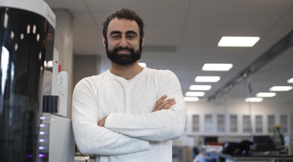 Armin Saatchi next to a mass spectrometer on loan to VIU from Thermo Fisher Scientific
