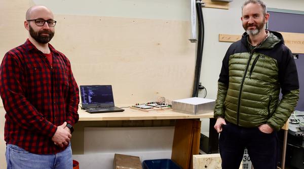 Engineering Technician Devin Ayotte and Resource Management and Protection Technician Michael Lester stand in front of marmot weigh scale