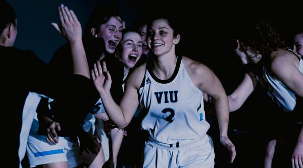 Amber runs by other basketball players giving high fives
