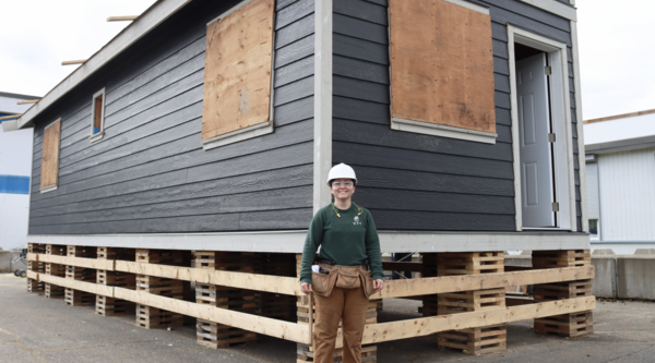 Carpentry student Emily Behm standing in front of the tiny home she and her classmates are building at the Cowichan Trades Centre