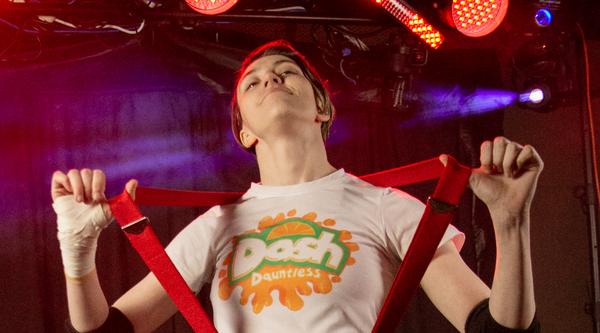 Meara Kimball is dressed in suspenders and jeans with a shirt that says Dash on it