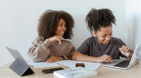 Two students studying together with their laptops open