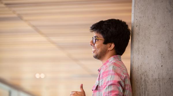 Student leaning against a pole