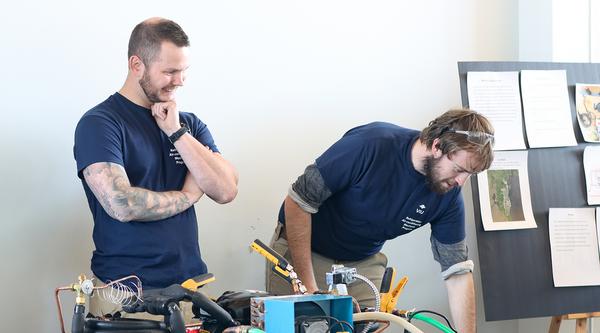 Two students showcase their Refrigeration and Air Conditioning Mechanic work for the food sovereignty project.