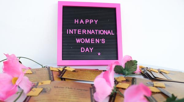 A small sign with a pink border that reads Happy International Women's Day