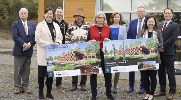 Nine people gathered around conceptual drawing of Shq’apthut (A Gathering Place) 