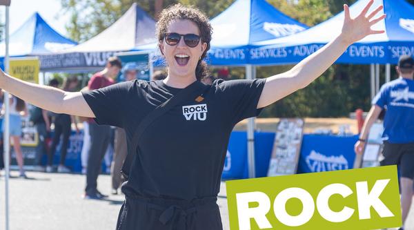Girl with arms spread wide, tents behind her