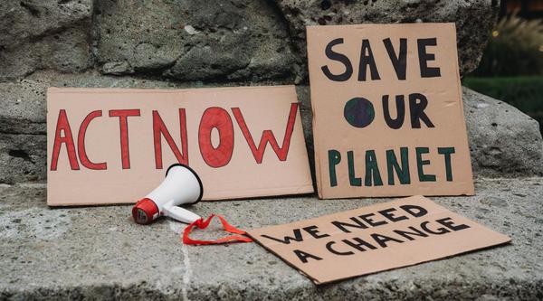 Climate action signs and a loudspeaker on pavement
