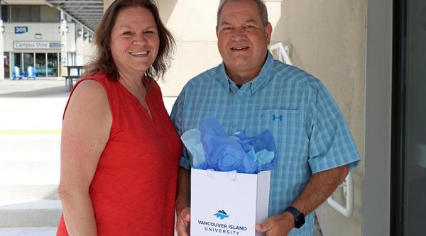 John with his wife Jen showing off the graduation gift he was given through the tuition waiver program