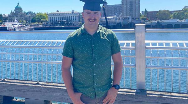 VIU Criminology grad Liam Kenney posing in his grad hat