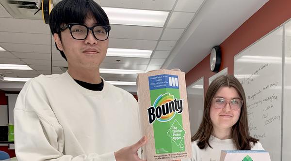 Nathan Pham and Kiara White hold their redesigned product packaging.