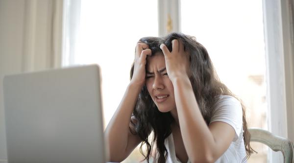 Girl staring at a computer screen with head in hands