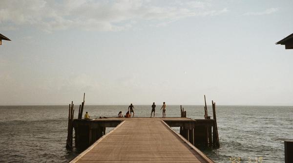 A dock with people on it, ocean behind