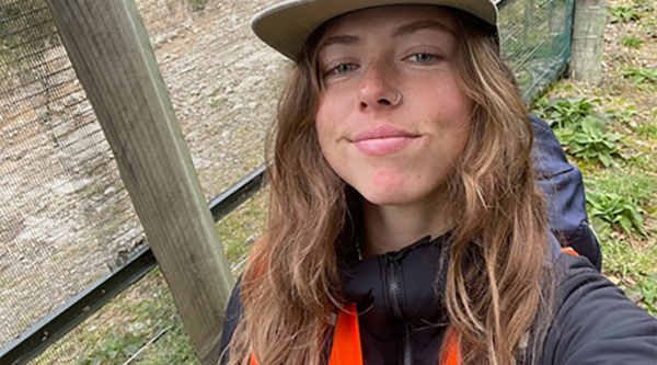 Georgia stands in front of a fence