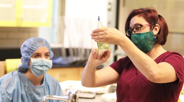 A student in a classroom watching an instructor fill a prescription bottle