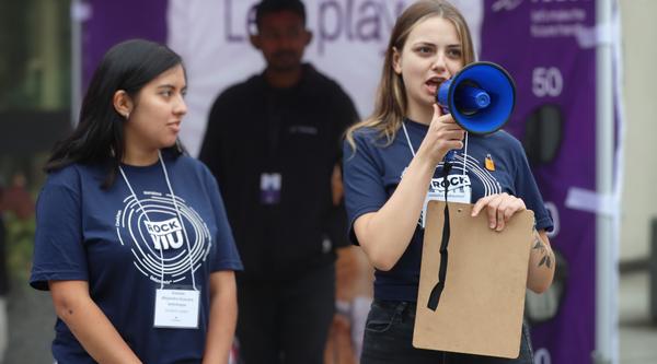 Two students wearing RockVIU shirts, one holding a loudspeaker