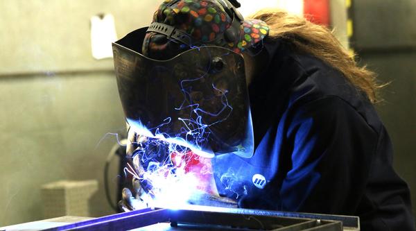 Head and shoulders of Sarah with a painting of ships behind her