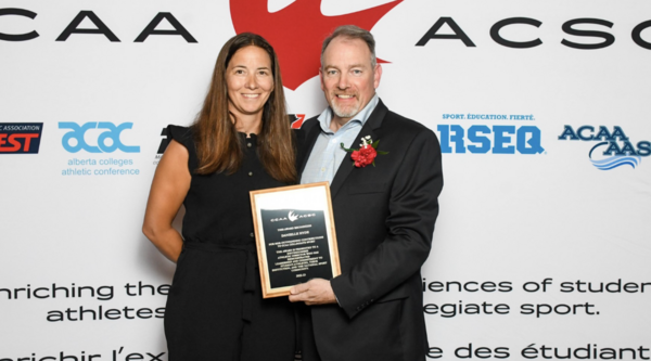 Danielle Hyde on the left receiving her award from a CCAA representative
