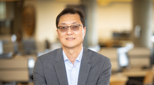Dr. Sungchul Cho sitting at a desk and smiling at the camera.
