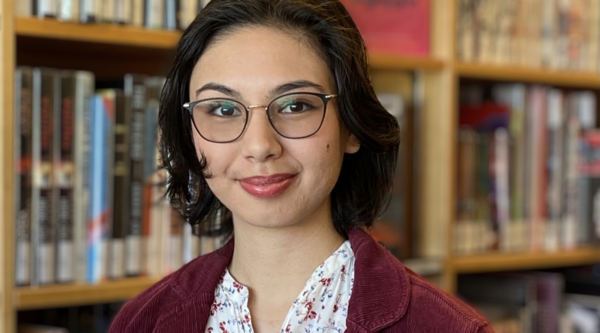 Chiara Sedola standing in front of a bookshelf and smiling at the camera