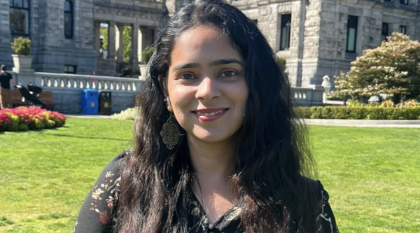 Harleen Kalra standing outside on a sunny day and smiling at the camera.