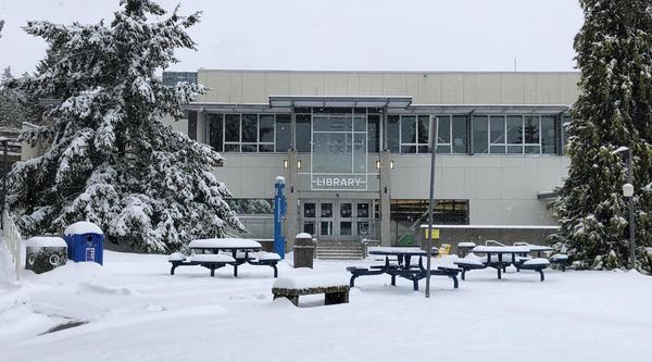 A view of VIU's Nanaimo campus library from the exterior with a snowed-in quad