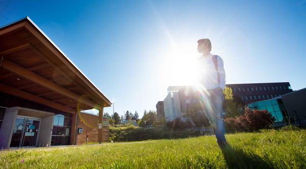 Student standing with the sun behind him