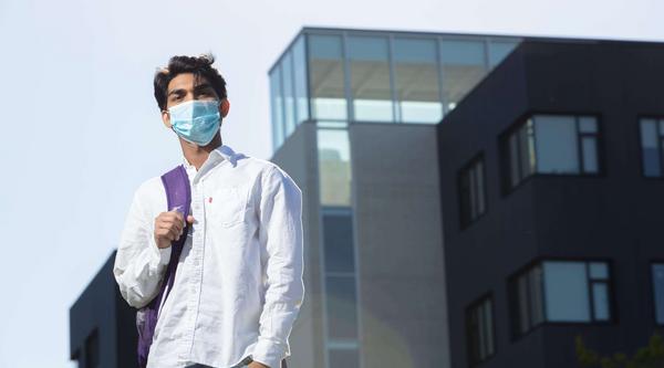 Student with backpack wearing a mask