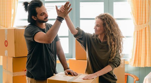 Students high fiving over moving boxes