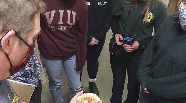 VIU students examine a scallop held by Provan Crump, from Coastal Shellfish Ltd.
