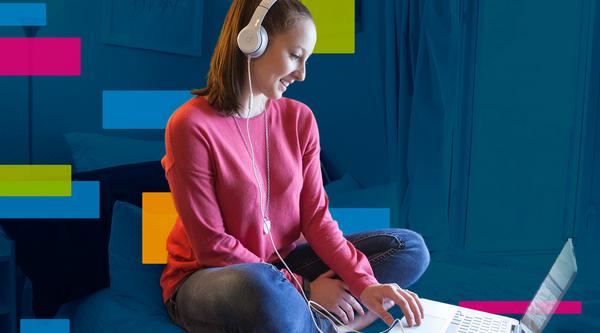 Girl with headphones on looking at a computer