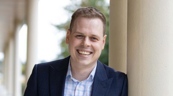 Xander leans against a pole outside VIU's Centre for Health and Science