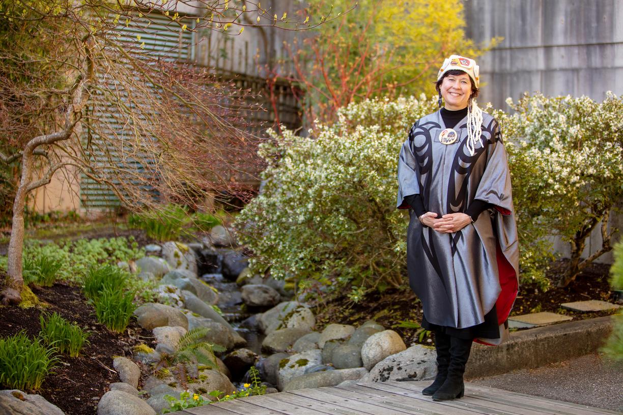 Deborah Saucier wears her convocation regalia and poses in the gardens at VIU's Nanaimo campus