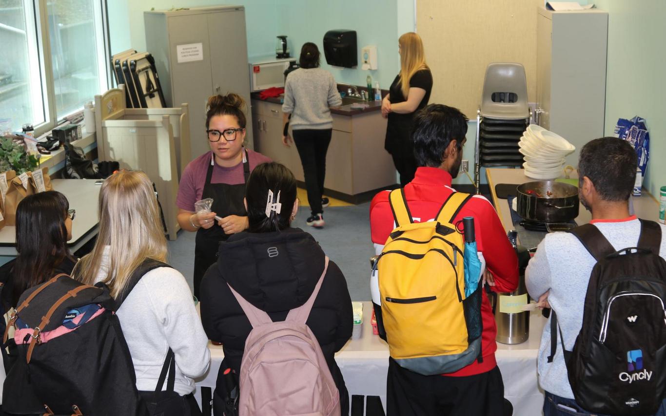 Leah serves food to students