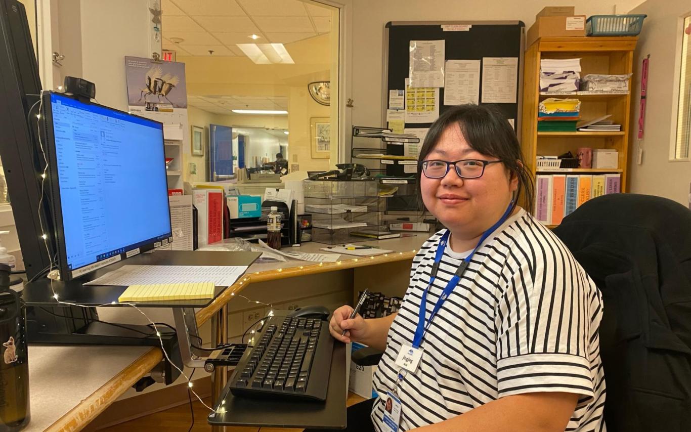 Jingjing sits at a desk in her hospital unit