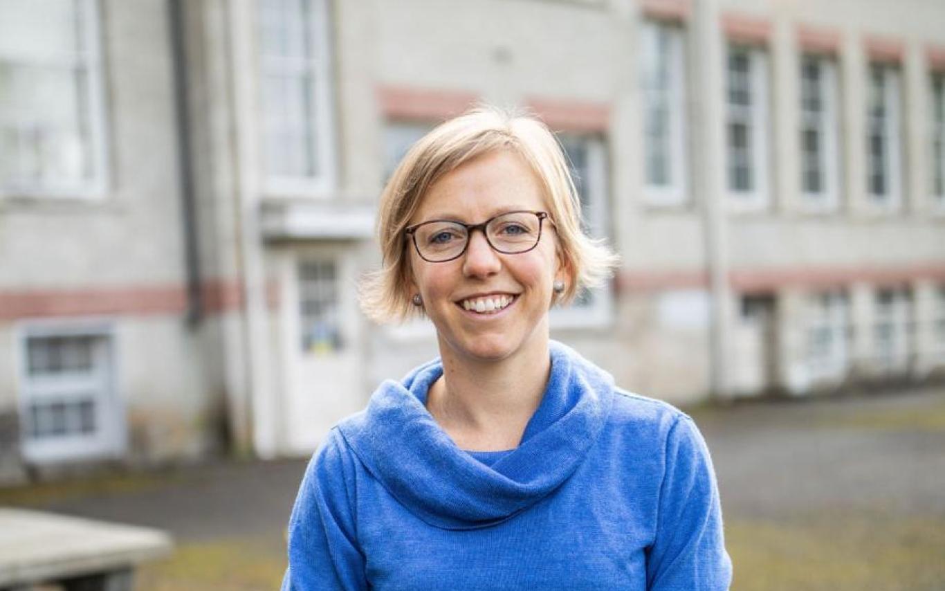 Alison Garnett sitting on table and smiling at camera