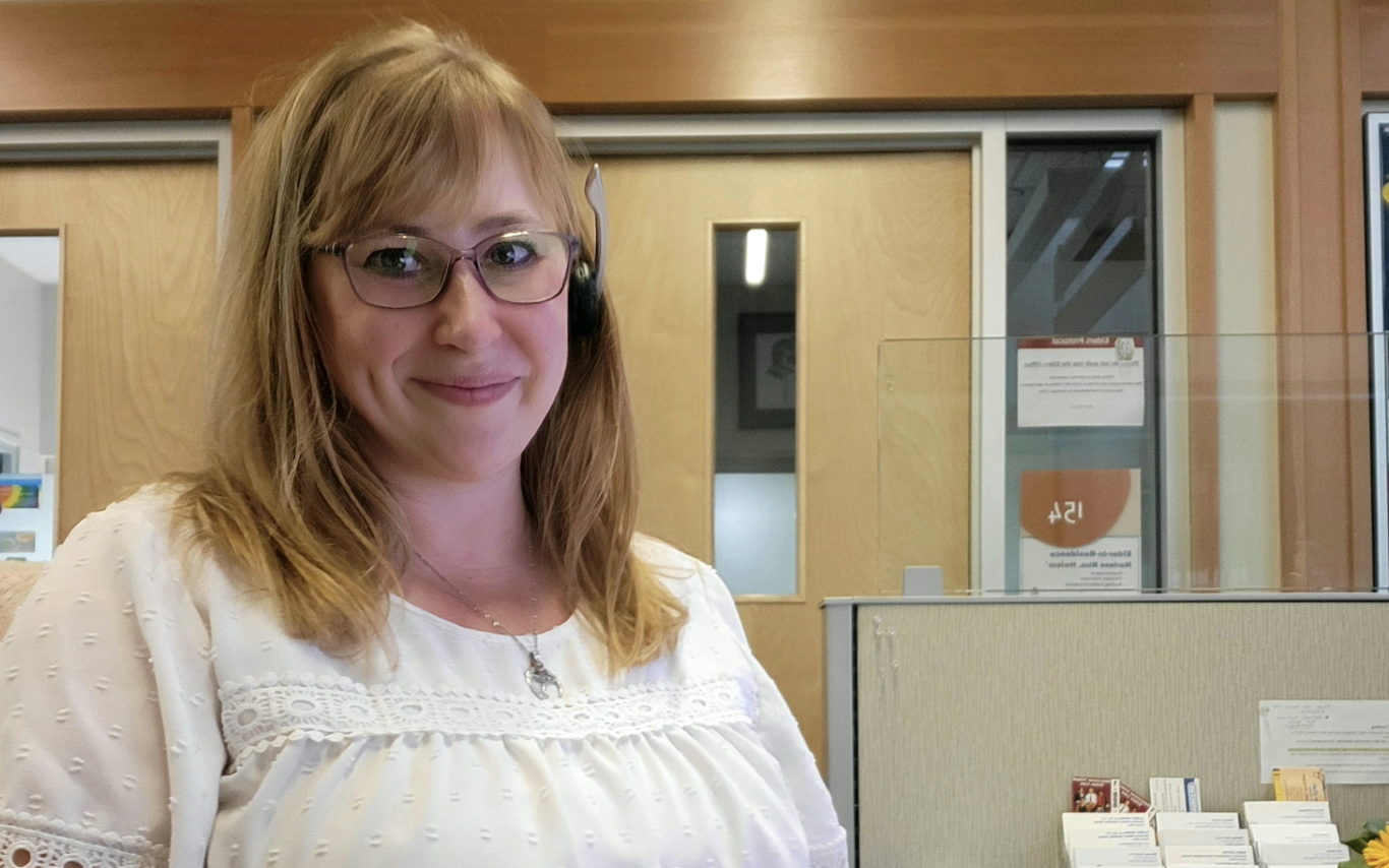 Amanda Rozenboom sitting at her work desk and smiling at the camera
