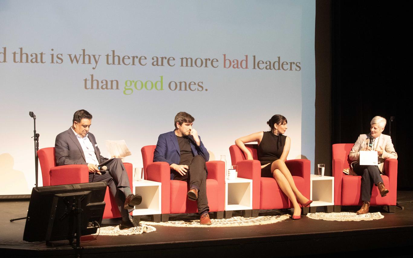 Four people sit on a stage together