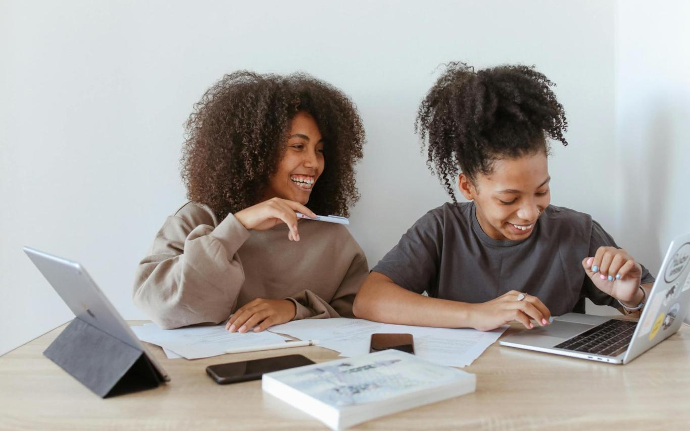 Two students studying together with their laptops open