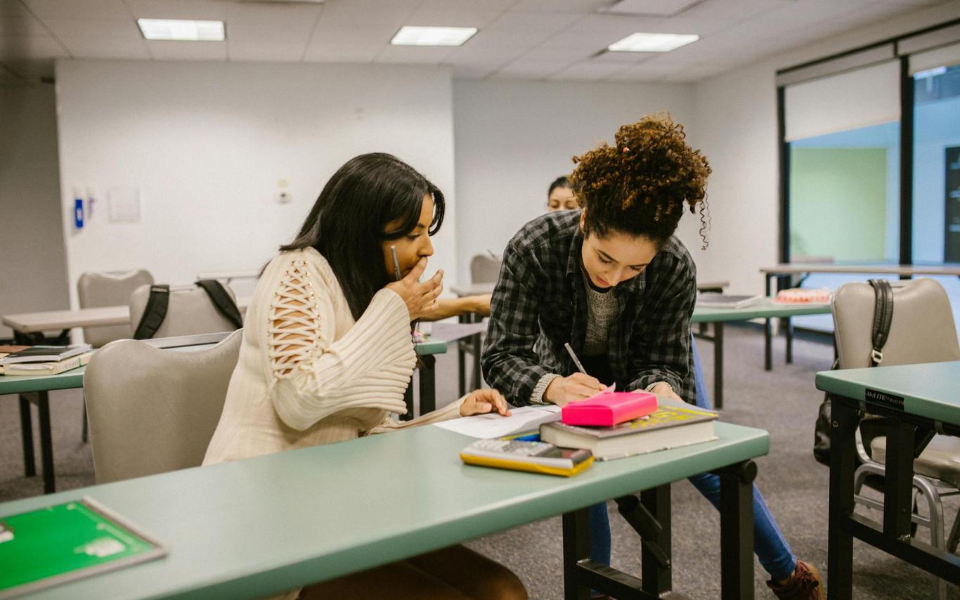 One friend helps another with homework
