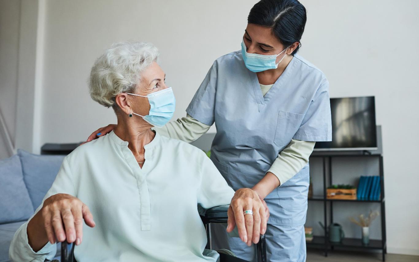 A health-care worker helps a patient