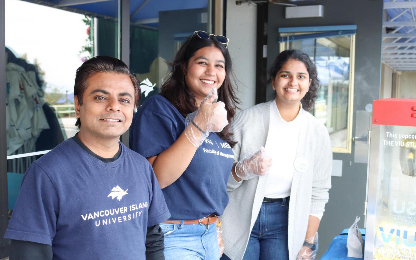 Three students serve food outside the cafeteria