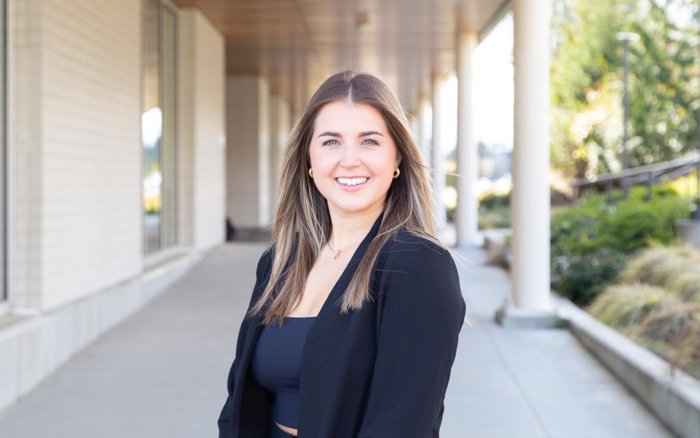 Olivia stands under the outdoor walkway outside the Centre for Health and Science at VIU
