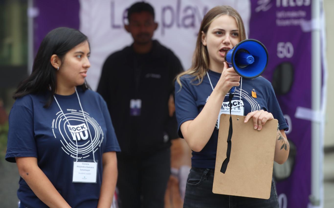 Two students wearing RockVIU shirts, one holding a loudspeaker