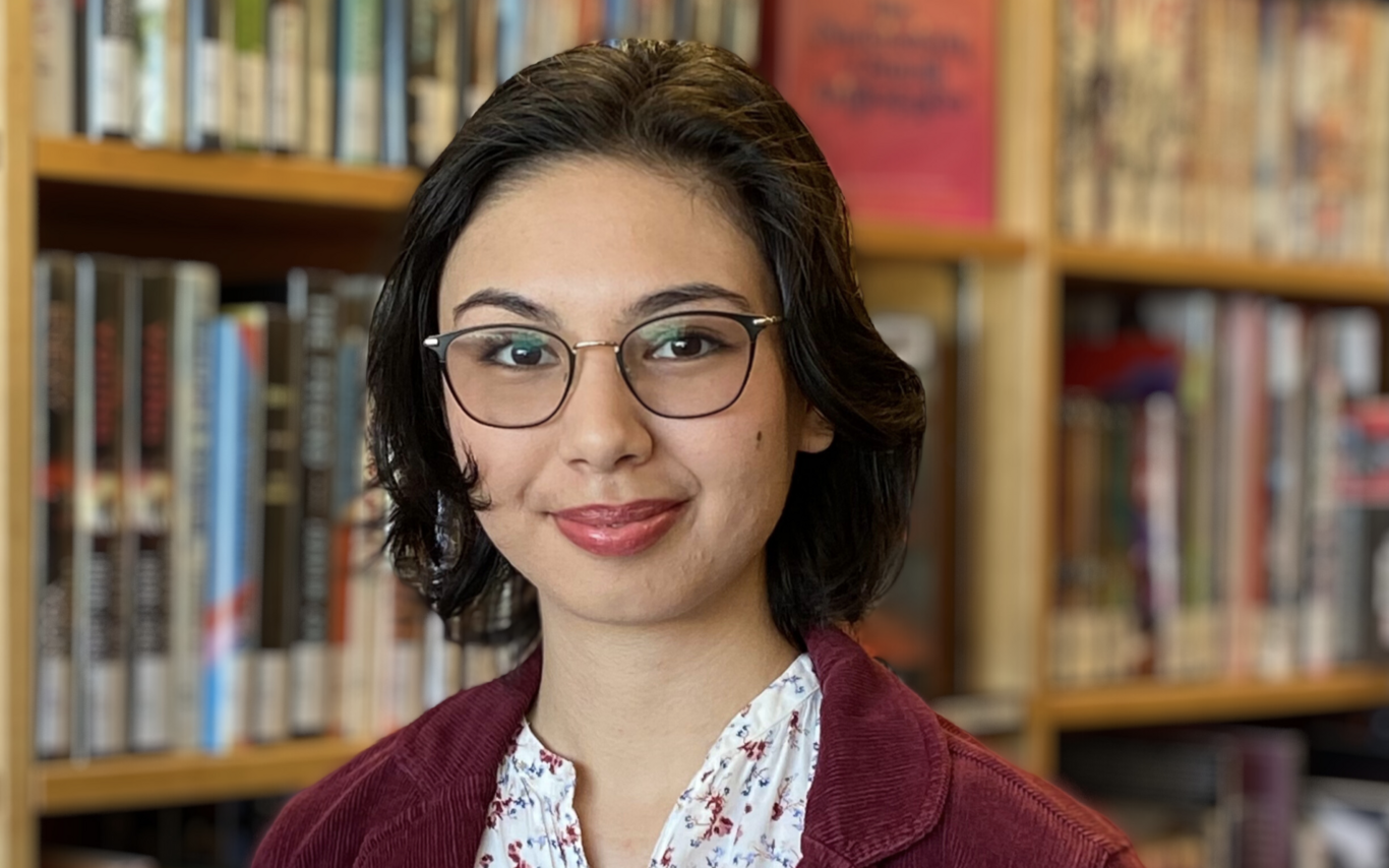 Chiara Sedola standing in front of a bookshelf and smiling at the camera