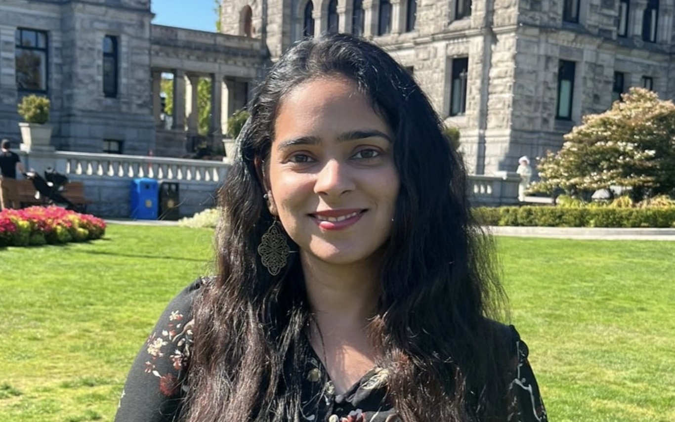 Harleen Kalra standing outside on a sunny day and smiling at the camera.